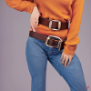 craiyon_134636_Stunningly_beautiful_woman_with_brown_hair__orange_sweater__blue_jeans__brown_belt__H.png
