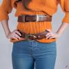 craiyon_134639_Stunningly_beautiful_woman_with_brown_hair__orange_sweater__blue_jeans__brown_belt__H.png