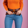 craiyon_134640_Stunningly_beautiful_woman_with_brown_hair__orange_sweater__blue_jeans__brown_belt__H.png