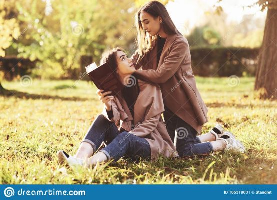 brunette-twin-girls-sitting-grass-looking-each-other-one-them-holding-brown-book-onother-one-brunette-twin-165319031.jpg