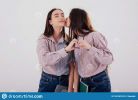 family-ties-girl-gives-kiss-two-sisters-twins-standing-posing-studio-white-background-165767675.jpg