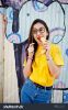 stock-photo-beautiful-fun-teenage-girl-with-banana-at-hand-wear-yellow-t-shirt-and-fake-glasses-near-graffiti-617116364.jpg