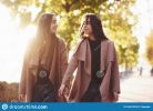 young-smiling-brunette-twin-girls-looking-each-other-holding-hands-casual-coat-walking-autumn-sunny-park-alley-blurry-165319239.jpg